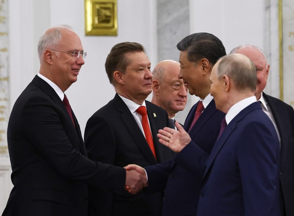 FILE – Chinese President Xi Jinping shakes hands with Kirill Dmitriev, the head of the Russian Direct Investment Fund, as Russian President Vladimir Putin looks on in Moscow, on May 8, 2025.