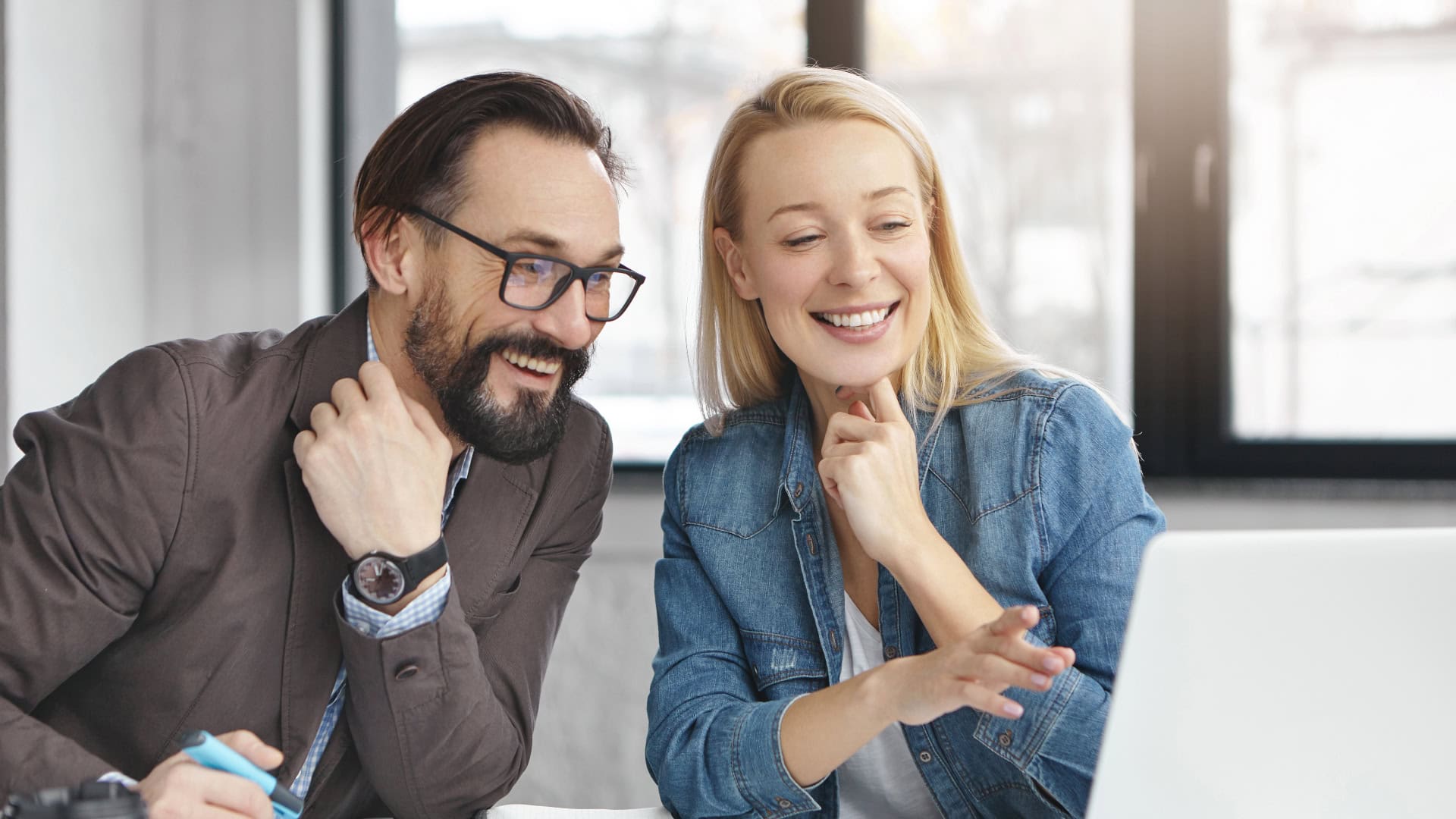 Na snímke dvaja kolegovia, ktorí sa usmievajú.