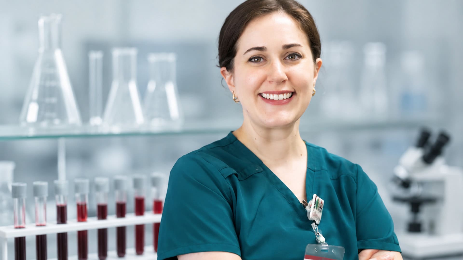 Asistentka patológa v laboratóriu so vzorkami krvi a mikroskopom