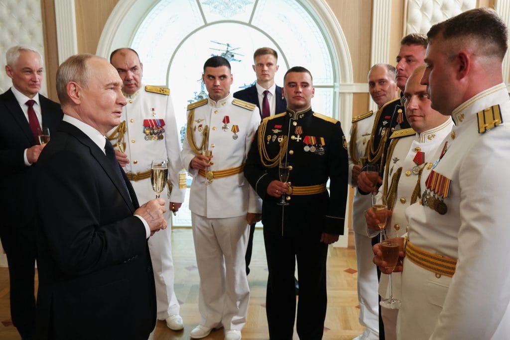 Ruský prezident Vladimir Putin , druhý zľava, pripíja s námornými dôstojníkmi na Deň námorníctva